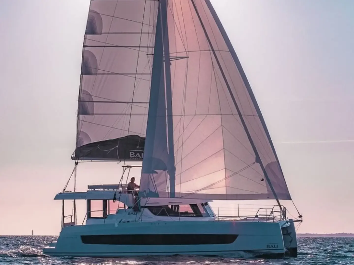 The Locke Catamaran under sail on calm water at golden hour